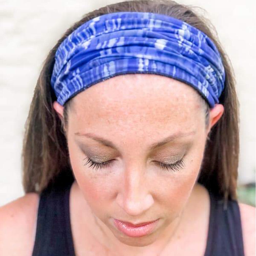 Adult woman wearing a blue dreams pattern face cover as a headband