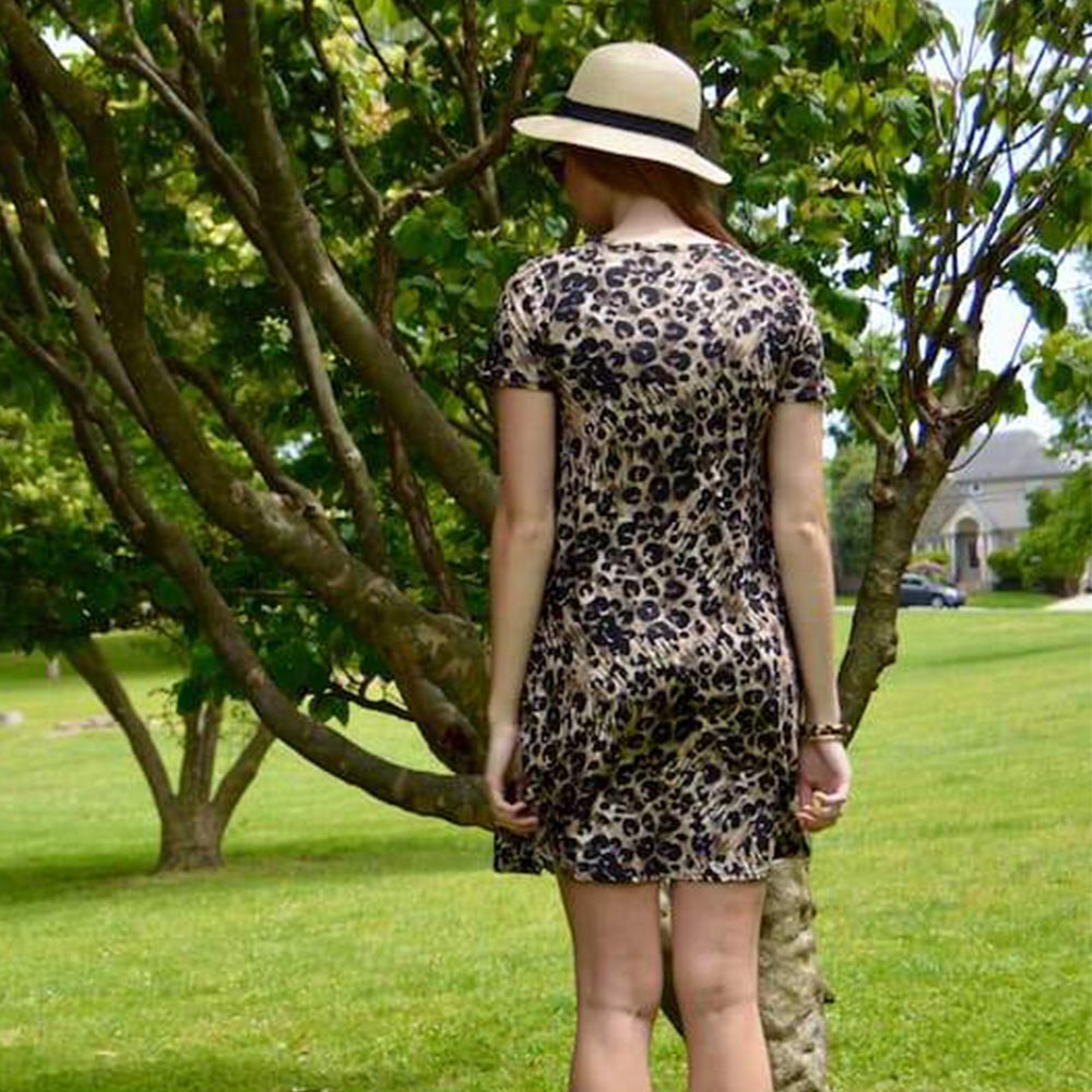 Model showing the back view of a leopard pattern dress by Jolina Boutique