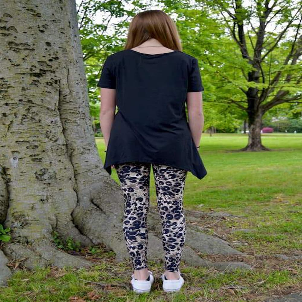 Model showing back view of her leopard pattern leggings sold by Jolina Boutique