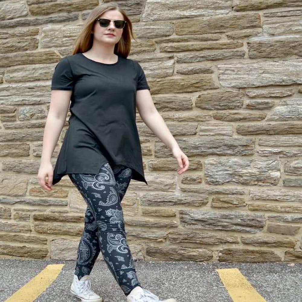 Model walking wearing black paisley pattern leggings by Jolina Boutique