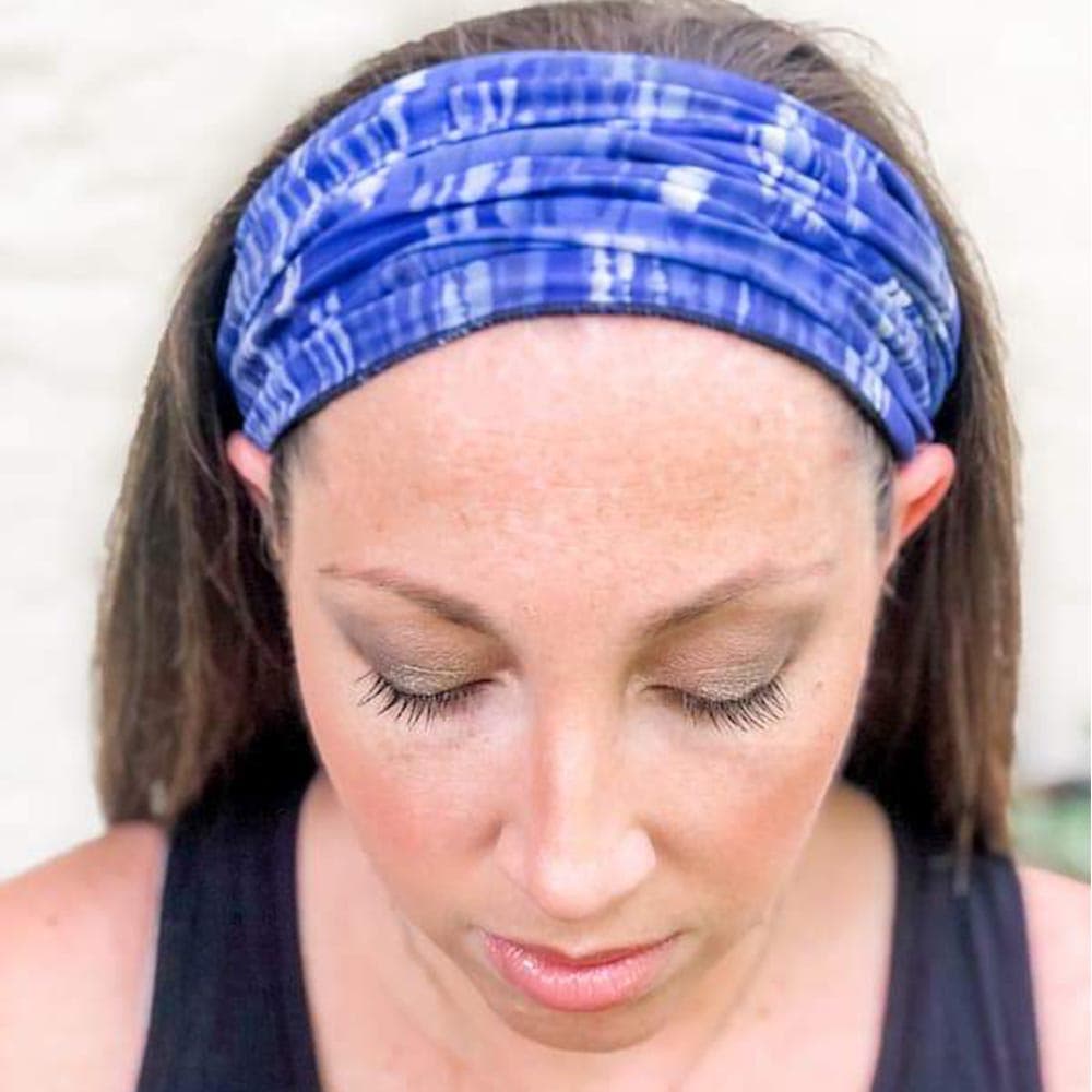 Adult woman wearing a blue dreams pattern face cover as a headband