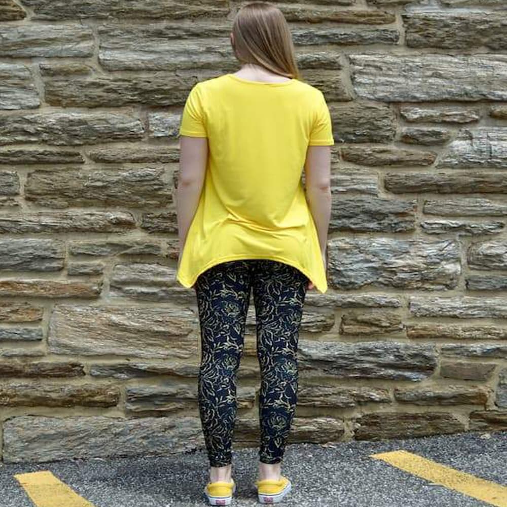 Model showing back view of golden rose pattern leggings by Jolina Boutique