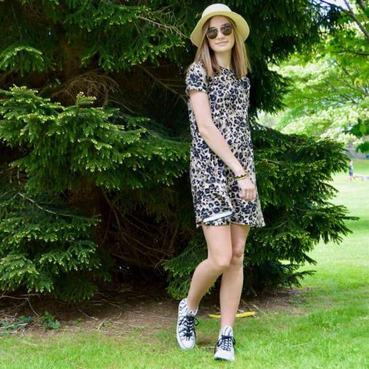 Leopard pattern dress worn by model in park by Jolina Boutique
