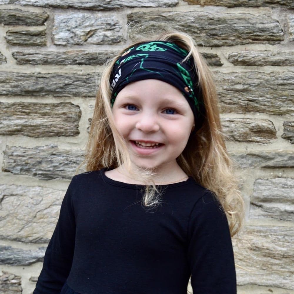 A kid female wearing a Philadelphia football bleed green face cover as a headband