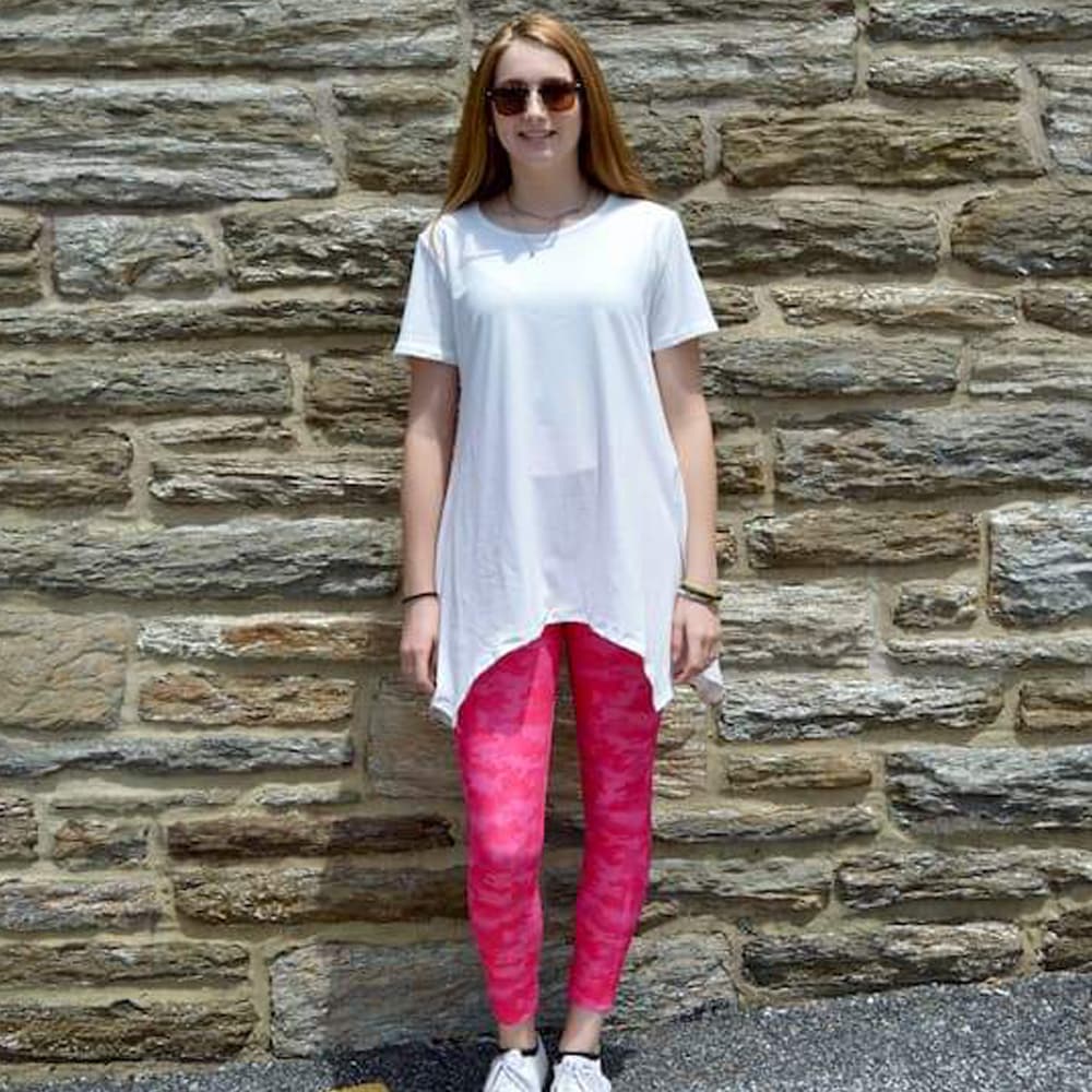 Model standing in front of wall wearing pink camo leggings