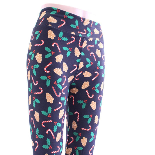 Tis the season Christmas leggings are black with colorful patterns of candy canes, mistletoes, and ginger cookies